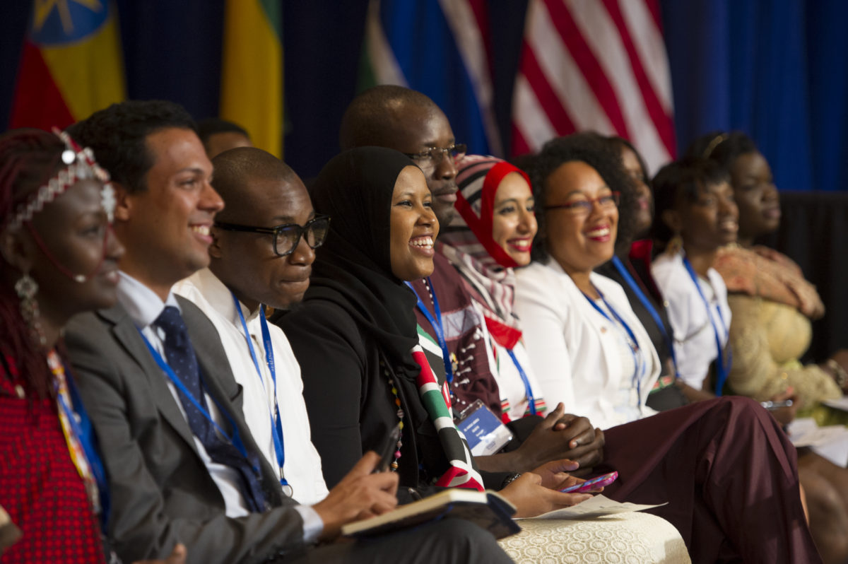 Fellows laugh while listening to a speaker at the 2014 Summit.