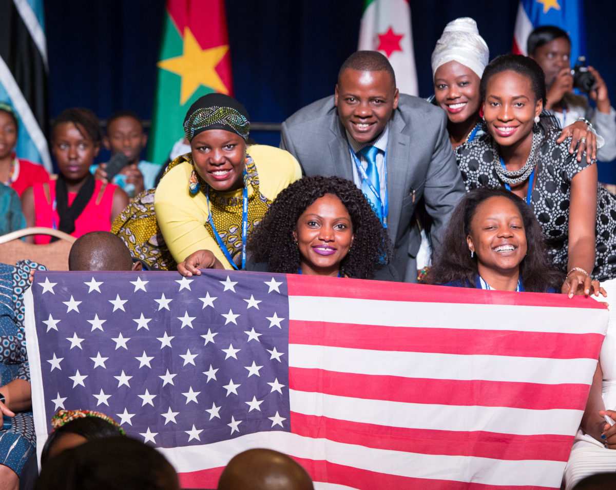 Fellows smile while holding an American flag at the 2015 Mandela Washington Fellowship Summit.