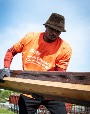 Georgia State Fellow participates in a community service project with Habitat for Humanity, carrying wood to build a house during their Mandela Washington Fellowship Leadership Institute.