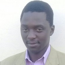 Headshot of a young man with short hair wearing a collared shirt and blazer