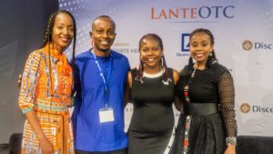 4 Alumni (3 female, 1 male) pose on stage after speaking on a panel at Africa Investor Week.