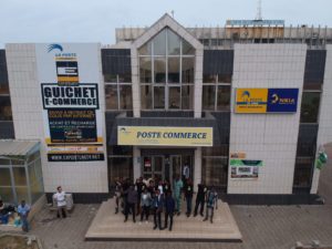 Exportunity staff stand on the steps of the Benin Postal Service.