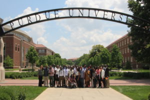 Laud Anthony Basing poses with the 2016 Purdue Institute cohort at university arch sign.