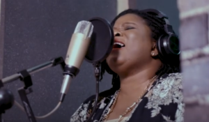 Fellowship Alumna Grace Jerry sings into a microphone