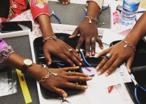 Close up of 4 womens hands wearing identical bracelets.