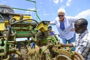 Two people examine farm equipment