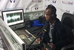 A man sits behind a desk at a radio station