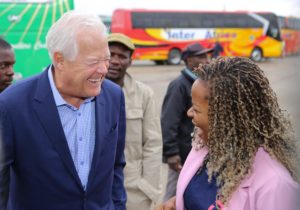 Two people laugh, facing each other in conversation