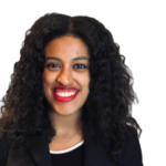 Headshot of a woman with curly hair in a black top and suit jacket; she smiles and wears red lipstick