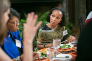 A woman engages in conversation at a luncheon