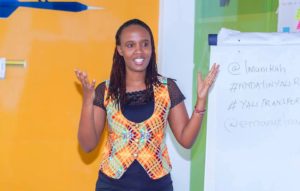 A young woman speaks at the front of a classroom