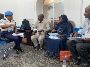 Woman in police uniform, left, speaks with 3 other individuals