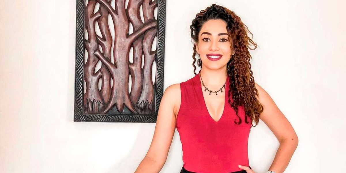 Photo of a young woman with curly hair in a red top