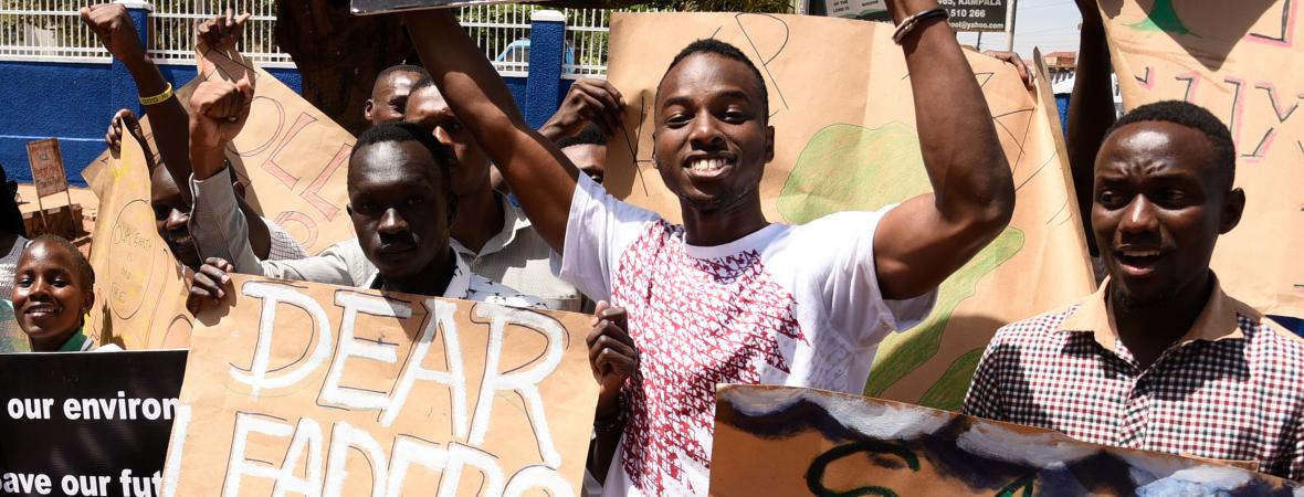 Young men hold up signs at a demonstration.