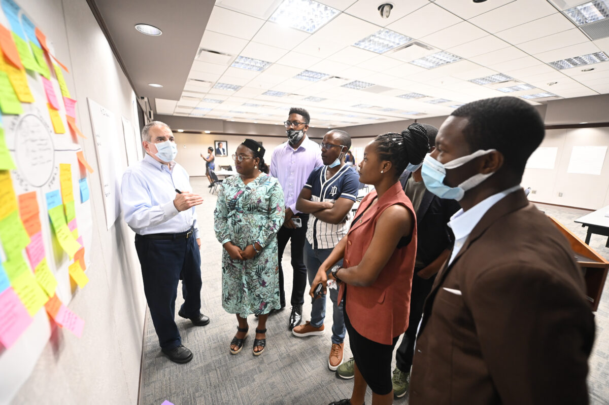 A group of people look at a flip chart while an instructor explains an exercise