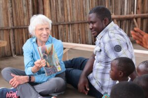 A woman reads a book to a group of children