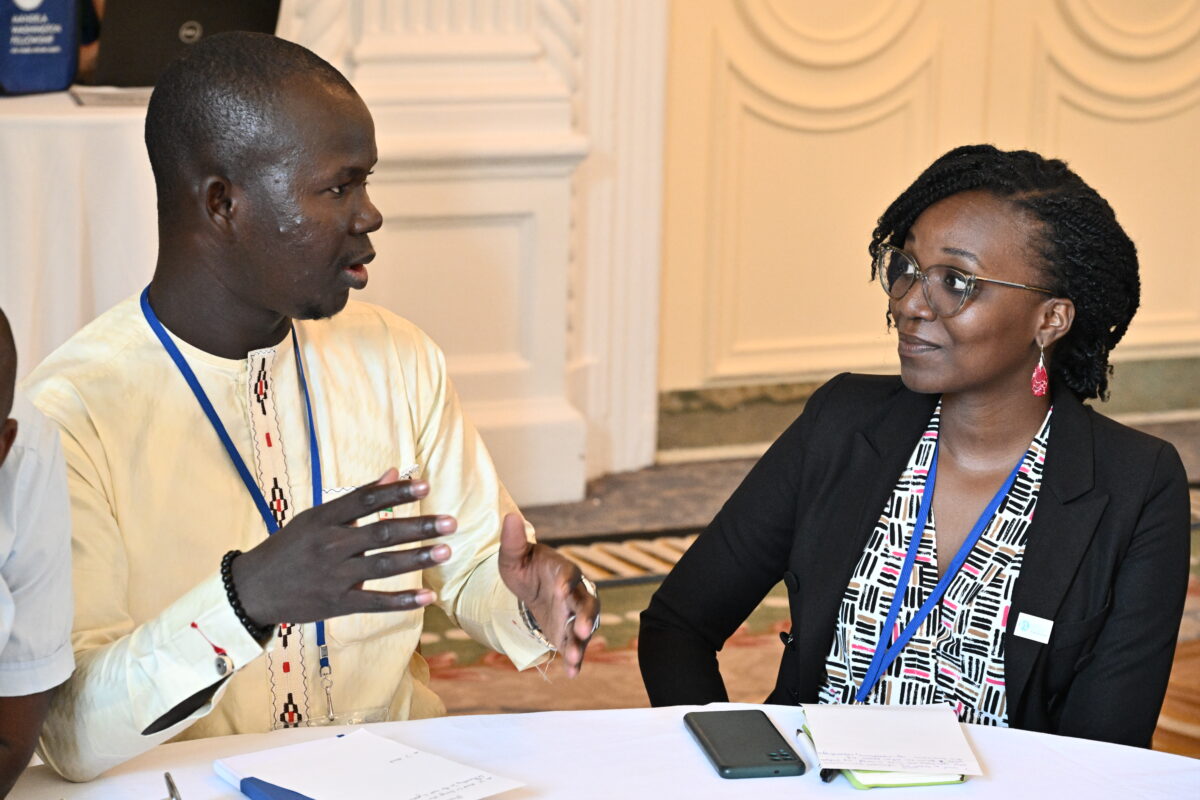 A man and woman sit at a table and converse