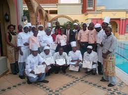 Group of people in white coats hold up certificates