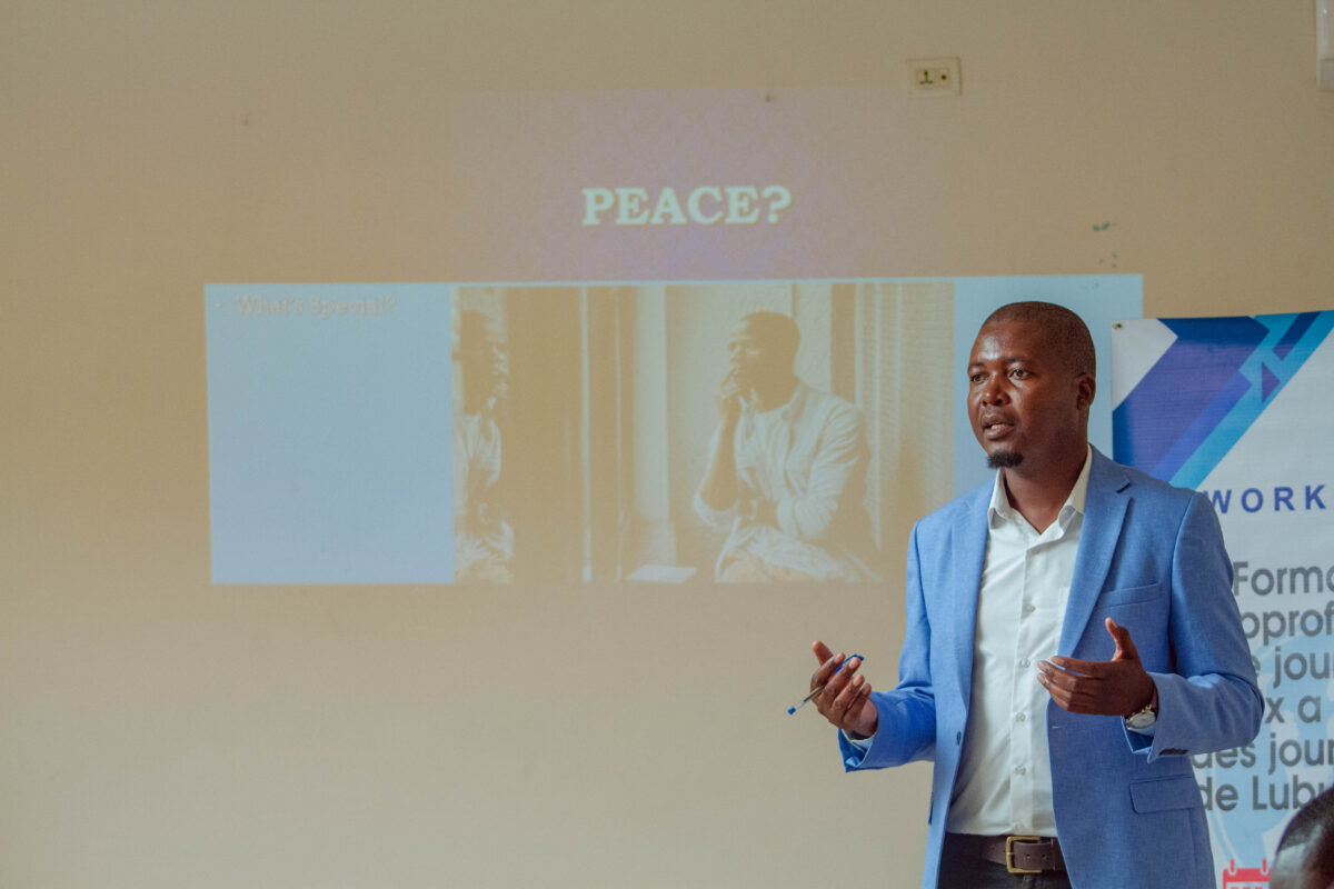 A man stands in front of a powerpoint presentation.